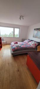 ein Schlafzimmer mit einem Bett und einem Holzboden in der Unterkunft 3-bedroom apartment with spectacular view in Neuenburg