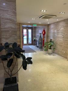 a hallway with a potted plant in a lobby at Praise Hotel Xujiahui Zikawei Shanghai Stadium 上海徐家汇赞寓酒店上海体育馆地铁站店 in Shanghai