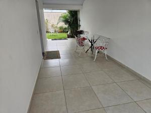 a hallway with a table and chairs on a tiled floor at Casa Brisa da ilha in Florianópolis