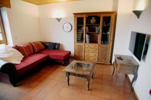 un soggiorno con un divano rosso e un tavolo di Ferienwohnung-Monteurwohnung in Einbeck-Kreiensen a Einbeck