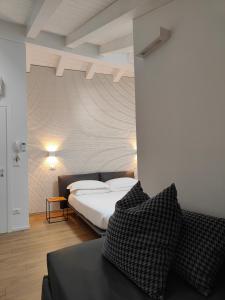 a bedroom with a bed and a couch at Borgo di Ponte Holiday Apartments & Rooms in Cividale del Friuli +26 photos