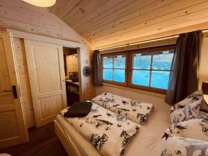 a small room with two beds and a window at Chalet Herbst in Lofer