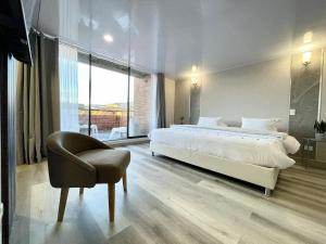 a bedroom with a large bed and a chair at Apartamento 7, Parque de la 93 in Bogotá