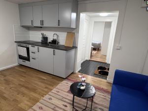 a kitchen with white cabinets and a table in a room at Entire Apartment 50 sqm Modern & Free Parking in Umeå