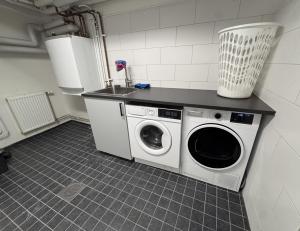 a kitchen with a washing machine and a sink at Entire Apartment 50 sqm Modern & Free Parking in Umeå