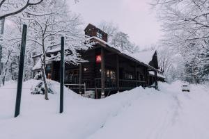 a building covered in snow in the snow at Double Black Hotel in Hakuba
