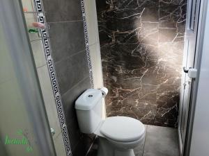 a bathroom with a toilet and a black marble wall at Inchalá - Apartamento cerca del Puente Internacional General Artigas in Paysandú +7 photos