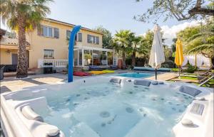 un jacuzzi en el patio trasero de una casa en Villa des 14 oliviers Piscine et Spa, en Le Luc