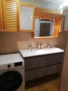 une cuisine avec deux lavabos et un lave-linge dans l'établissement Chalet Paolina proche le Grand Bornand et la Clusaz, à Glières-Val-de-Borne