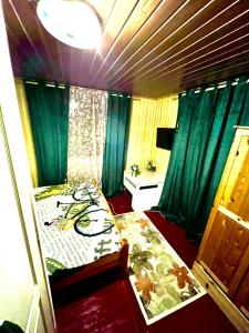 a bedroom with a bed and green drapes at Cabană B&M in Slănic-Moldova