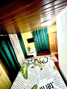 a room with a bed and a table with green curtains at Cabană B&M in Slănic-Moldova