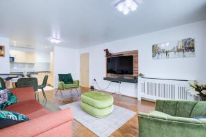 a living room with a couch and chairs and a tv at Newly furnished stunning 2 bedroom flat in Colindale