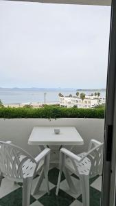 a white table and chairs on a balcony with the beach at Appartement à Tanger Vue Mer in Tangier +5 photos