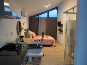 ein Schlafzimmer mit einem Bett, einem Schreibtisch und einem Spiegel in der Unterkunft Ginjas Mountain Houses in São Vicente