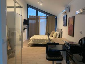 ein Wohnzimmer mit einem Bett und einer Glastür in der Unterkunft Ginjas Mountain Houses in São Vicente