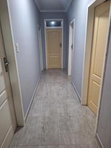 pasillo con paredes blancas, puerta y suelo de baldosa en The Cosy Nook, en Germiston