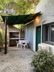 a patio with a table and chairs next to a house at Tindet in Playa Hermosa