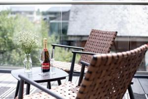eine Flasche Wein auf einem Tisch mit zwei Stühlen in der Unterkunft Maricor in South Cerney + 33 Fotos