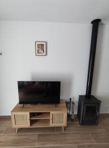 a living room with a television and a wood stove at Casa rural La Pinada in Villanueva de Viver