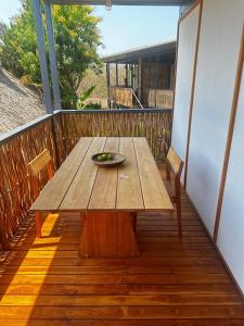 a wooden table on a balcony with a plate on it at La Paz Perfecta a Playa Saladita in Temalhuacán