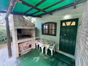 a room with a table and chairs and a green door at Tindet in Playa Hermosa