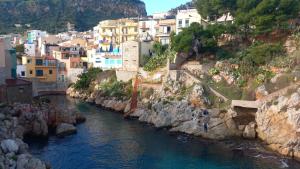 a group of houses on a hill next to a river at La Terrazza Solarium, in pieno centro 60m dalla stazione ferroviaria 700m dal mare in Santa Flavia