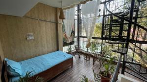 a room with a bed and a balcony with plants at Yes Retreat Rishikesh in Rishīkesh