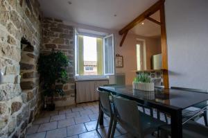 a dining room with a table and a brick wall at Casamea - Apt Spacieux, Clim, Famille & Cabane in Ajaccio