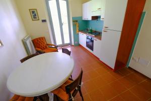 a small kitchen with a white table and chairs at Agriturismo Sant'Agostino in San Giovanni dʼAsso