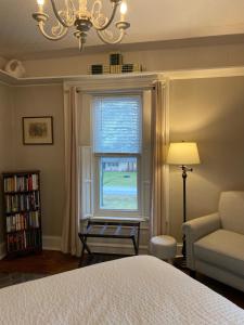 a bedroom with a bed and a chair and a window at The Vine Bed & Breakfast, LLC in Dundee