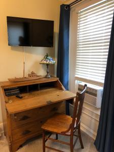 a desk with a television and a chair in front of a window at The Vine Bed & Breakfast, LLC in Dundee