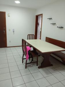 a table with a pink stuffed animal sitting on a chair at Apartamento Itapema in Itapema +4 photos