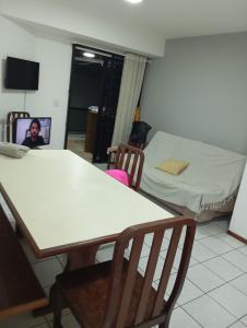 a room with a table and chairs and a bed at Apartamento Itapema in Itapema