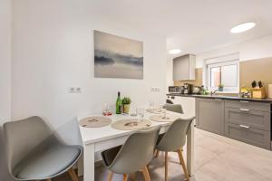 cocina con mesa blanca y sillas en Sali Homes Ziegeleihaus, en Heilbronn
