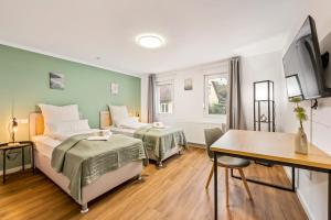 Una habitación de hotel con dos camas y un escritorio. en Sali Homes Ziegeleihaus, en Heilbronn