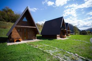 科拉欣BB CHALET的绿色田野上带黑色屋顶的小小屋