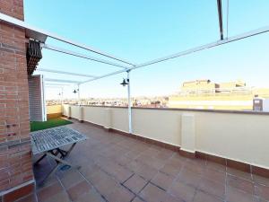 a balcony with a bench and a view of a building at Madrid Luxe Oasis 4 Bedroom with Terrace & Pool in Torrejón de Ardoz