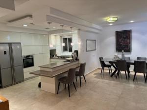 a kitchen and dining room with a table and chairs at Awesome Apartment Netanya in Netanya
