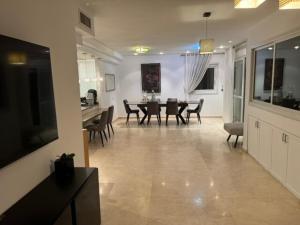 a living room with a table and a dining room at Awesome Apartment Netanya in Netanya