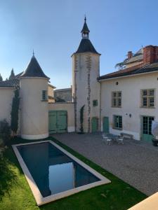 GenayChâteau de Rancé的建筑前带游泳池的庭院