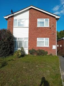 a brick house with white windows and a yard at Family room in Broadstone