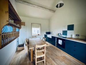 a kitchen with a wooden table and blue cabinets at Apartment at Llanerchydol Hall in Welshpool +17 photos