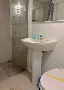 een witte badkamer met een wastafel en een toilet bij Chambre équipée dans appartement de village in Magagnosc