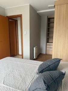 a bedroom with a bed with two pillows on it at Depto 2 dormitorios - LIBERTADOR in Vuelta del Paraguayo