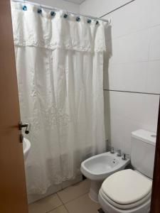 a bathroom with a toilet and a shower curtain at Depto 2 dormitorios - LIBERTADOR in Vuelta del Paraguayo