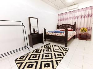 - une chambre avec un lit, un miroir et un tapis dans l'établissement D'Amal Homestay Alor Setar, à Alor Setar