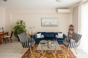 a living room with a blue couch and two chairs at Cozy apartment in the center in Tripoli