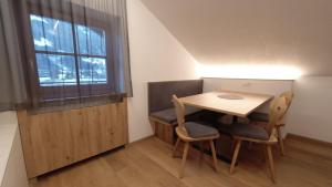 a small table and chairs in a room with a window at Garberhof-Stocker in Campo Tures