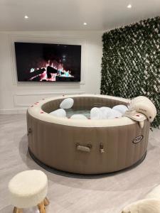 a living room with a hot tub and a tv at F2 jacuzzi moderne et spacieux in Étampes