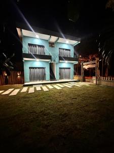 ein blaues Gebäude in der Nacht mit Lichtern in der Unterkunft Suítes Flor de Maio in Porto Seguro